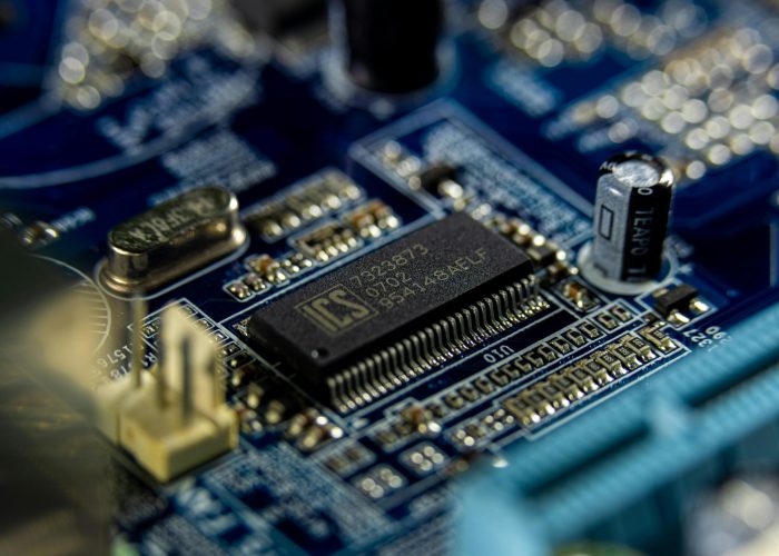 Detailed shot of a microprocessor on a blue motherboard showcasing electronic components.
